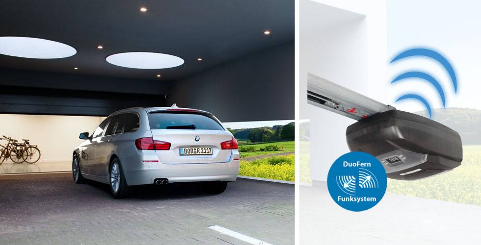 Ein silberner BMW fährt in eine moderne Garage, rechts ein Garagentorantrieb mit DuoFern Funksystem-Symbol.